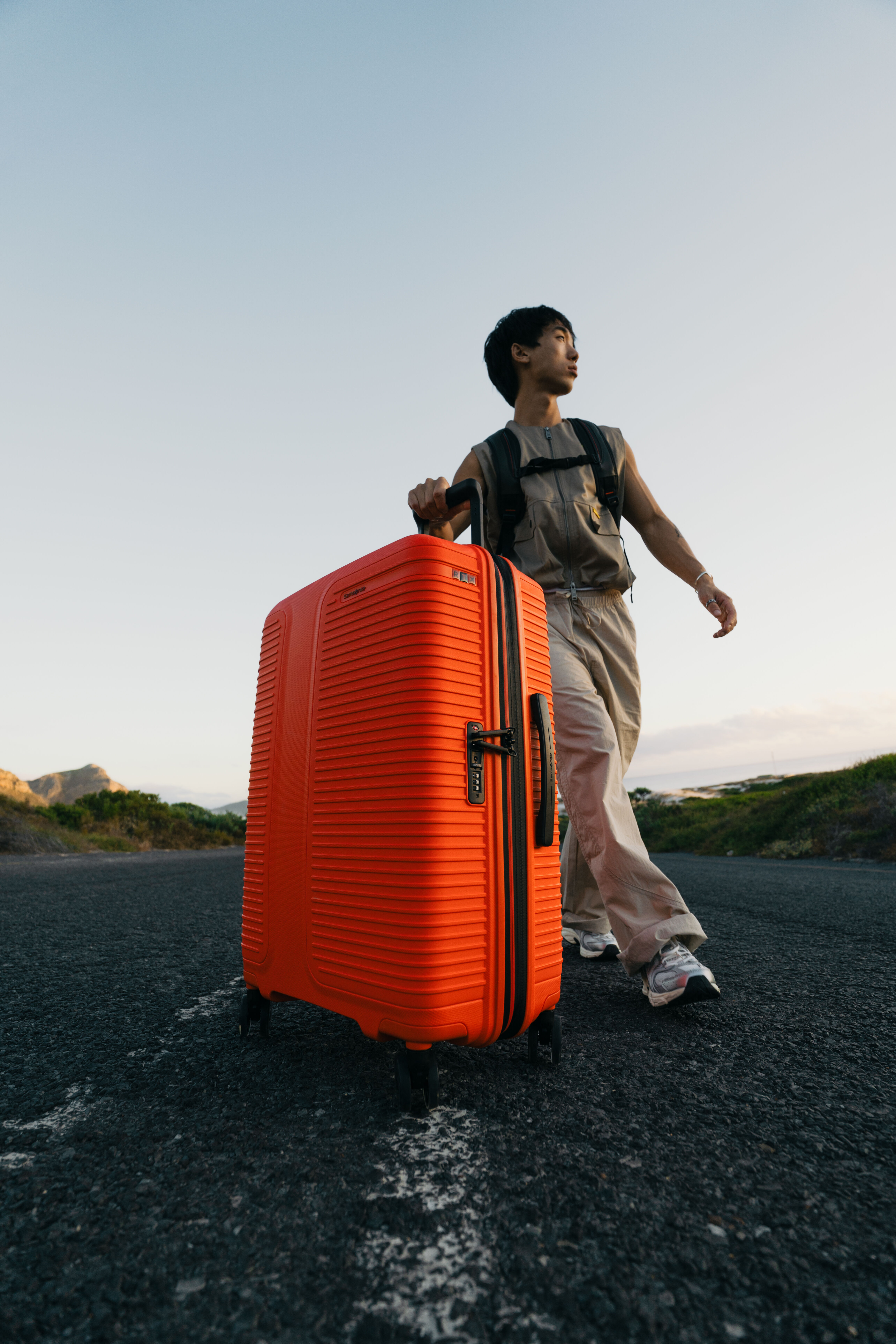 Lifestyle image: person on a trip with large orange hardside suitcase